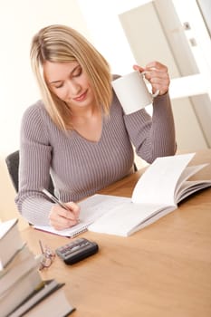 Blond girl writing homework