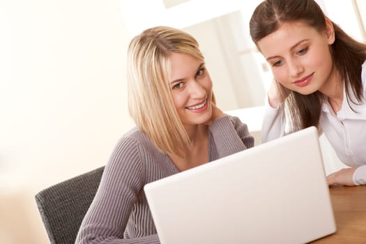 Two girls sitting at laptop