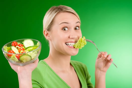 Healthy lifestyle - woman holding vegetable salad on green background