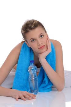 Fitness - Young sportive woman with water and towel on white background