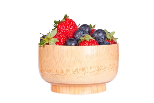 Blueberries and strawberries in a bowl isolated on white background. Shallow depth of field