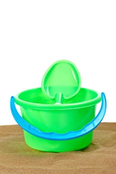 Bucket full and shovel on the sand with copy space on a white background. Shallow depth of field