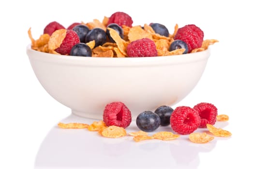 A bowl of cornflakes with fruits on white background. Shallow depth of field
