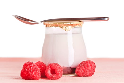 Delicious glass yogurt with a spoon and fresh raspberries and blueberries. Shallow depth of field