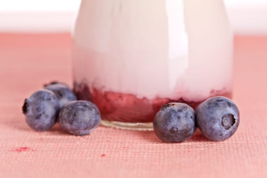 Delicious glass of yogurt and fresh blueberries. Shallow depth of field