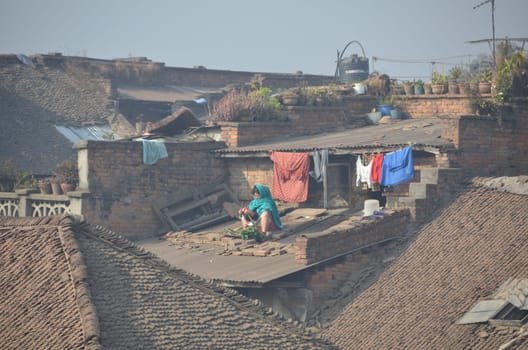 Nepal 2011, woman prepares clothes on a rooftop