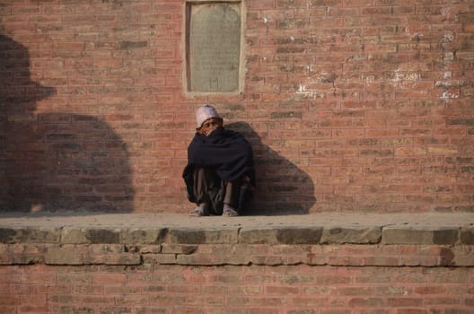 old Nepal man sitting on a wall