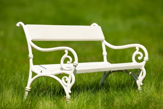 Spring and summer - White romantic bench in meadow on sunny day