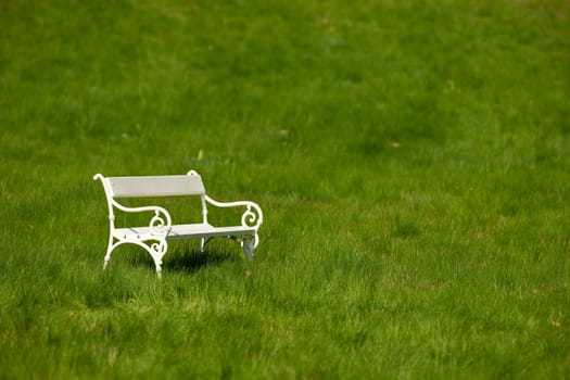 Spring and summer - White romantic bench in meadow on sunny day