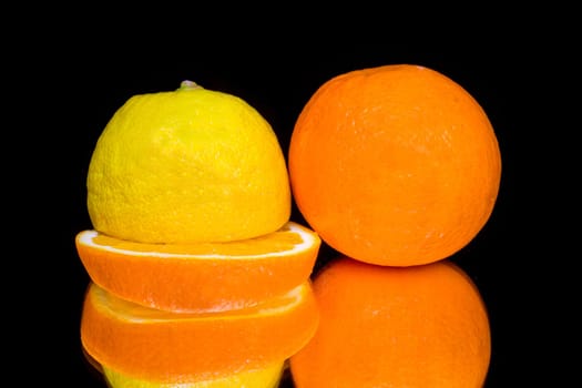 Lemon and orange isolated on black background