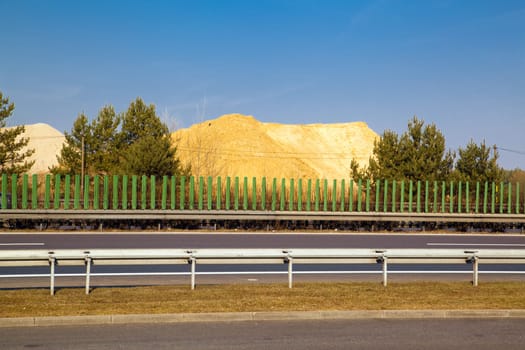 Side view of the motorway and sand hit in background