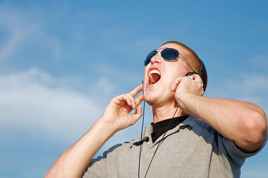 A cool young man listens to music on some headphones