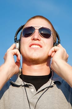 A cool young man listens to music on some headphones