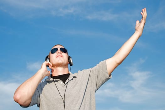 A cool young man listens to music on some headphones