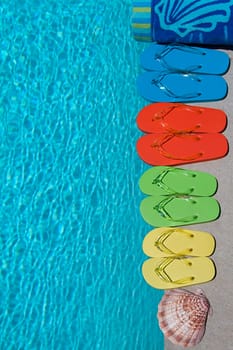 Colored flipflops of a family of four by the swimming pool