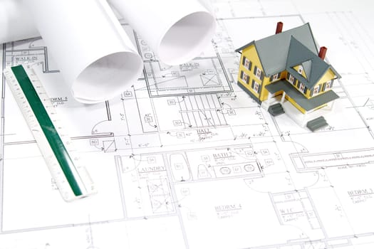 Residential home blueprints with a hand-made house model.