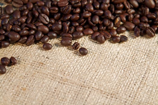 Coffee beans spilling from a burlap sack and fresh coffee