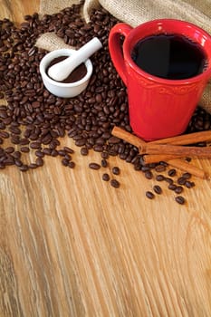 Coffee beans spilling from a burlap sack and fresh coffee
