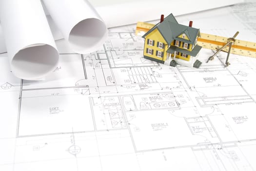 Residential home blueprints with a hand-made house model.