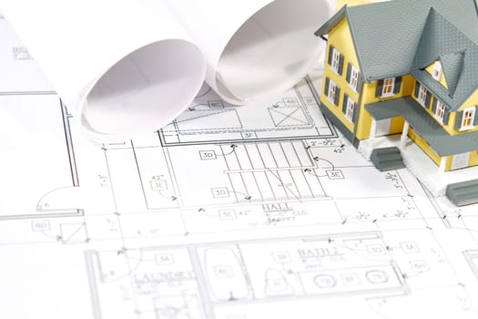 Residential home blueprints with a hand-made house model.