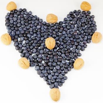 Blueberries and walnuts in the shell arranged in the shape of love.