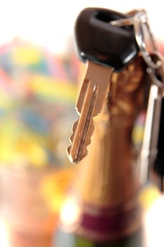champagne bottle with keys hanging on bottle on white background depicting drunk driving and addictions can kill