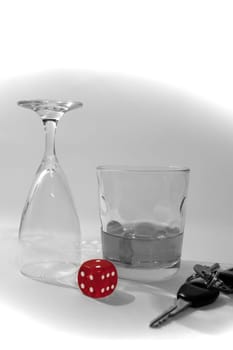 dice and whiskey glass with car keys in black and white with dice in red depicting gambling with drunk driving and addictions can kill