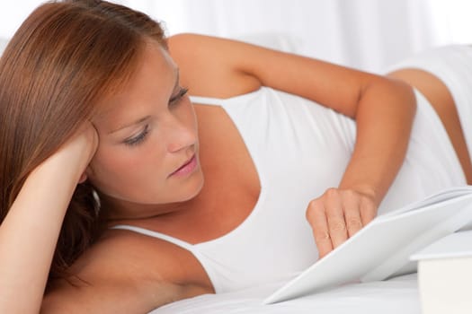 Young woman reading white book, shallow DOF