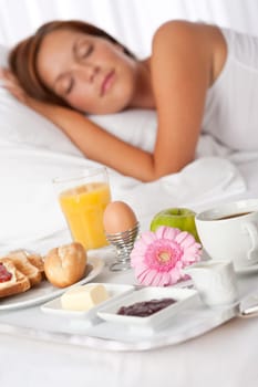 Young woman having breakfast in luxury hotel room