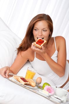 Young woman having breakfast in luxury hotel room