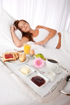 Young woman having breakfast in luxury hotel room