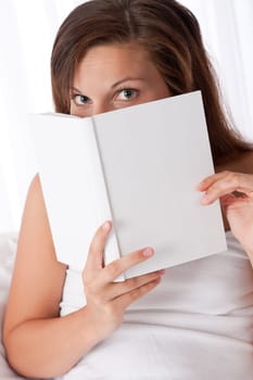 Brown hair woman peeking over white book