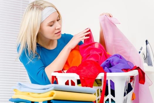 Laundry - woman folding clothes home, housework
