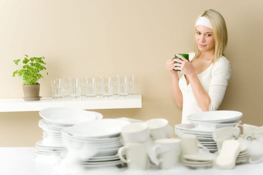 Modern kitchen - happy woman washing dishes having coffee break