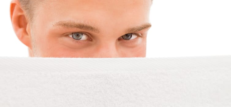 Relaxed young blond handsome man hidind behind white towel