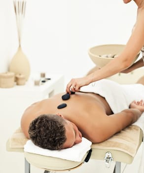Young man enjoying the treatment in spa salon
