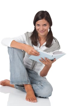 Smiling teenager holding book on white background