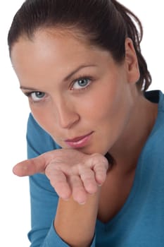 Happy young woman blowing a kiss on white background