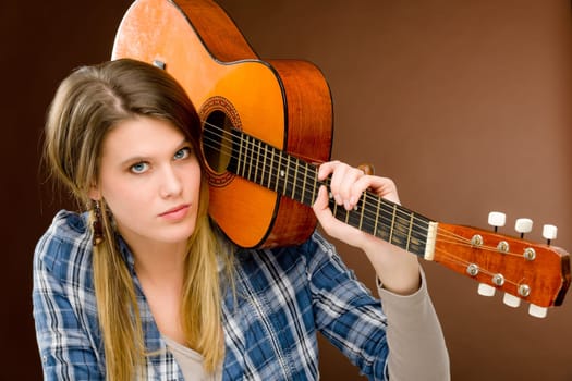 Rock musician - young fashion female model posing with guitar