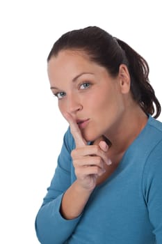Beautiful young woman with finger on lips on white background