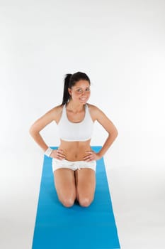 young woman exercising on blue carpet, vertical