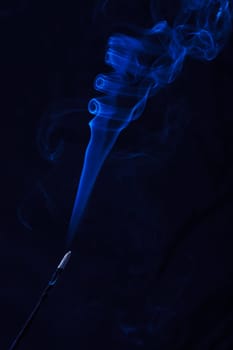 Abstract incense blue smoke against black background