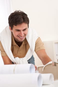 Successful architect man working at office with plans and architectural model