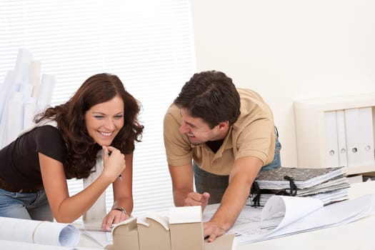 Smiling man and woman working at architect office office