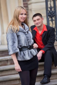 romantic couple - man sitting on steps and looking at woman