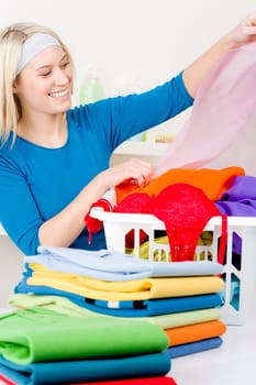 Laundry - woman folding clothes home, housework