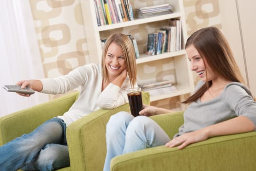 Students - Two female student relaxing home watching TV and drinking coke