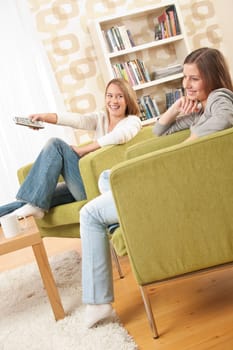 Students - Two female student relaxing home watching TV