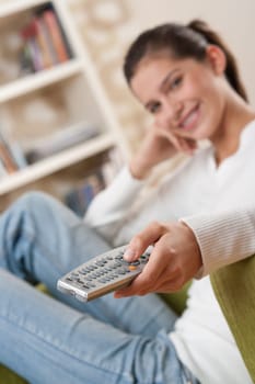Students - Smiling female teenager watching television in living room
