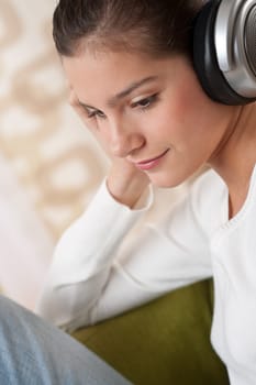 Students - Happy female teenager with headphones listening to music in modern lounge